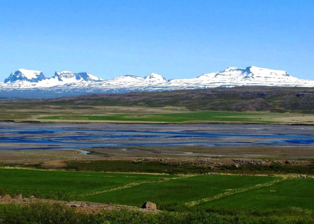 Snow-capped mountains and green valley near Litlabjarg Guesthouse in East Iceland